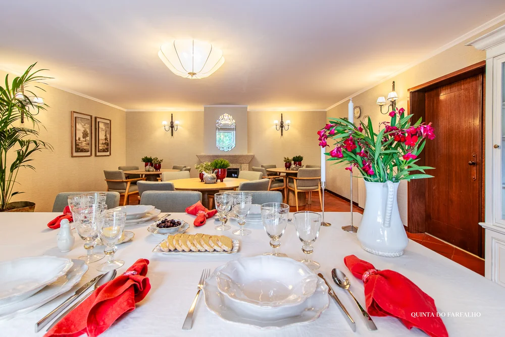 The quinta’s dining room with flowers, terracotta floors, and a table set for a meal